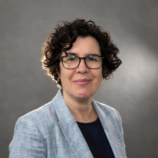 Dr Tamsin Wesley — head-and-shoulders portrait, light blue blazer over a navy top